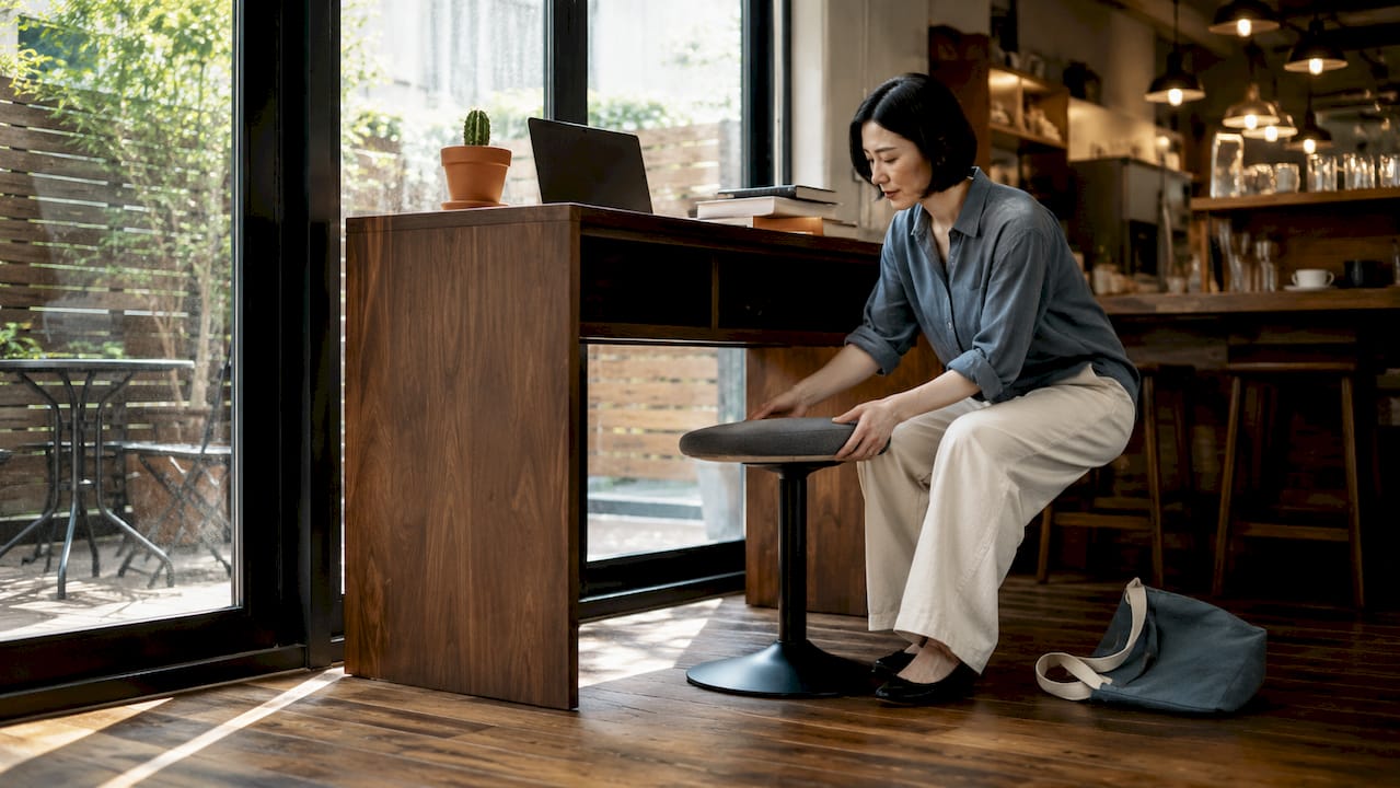 Woman adjusting ergonomic chair in stylish home office