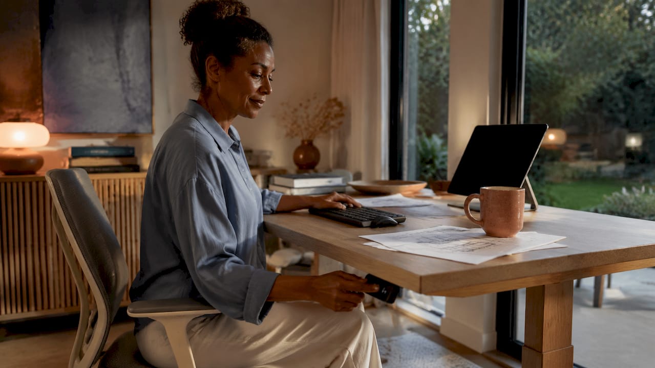 Woman adjusting height on luxury home office desk
